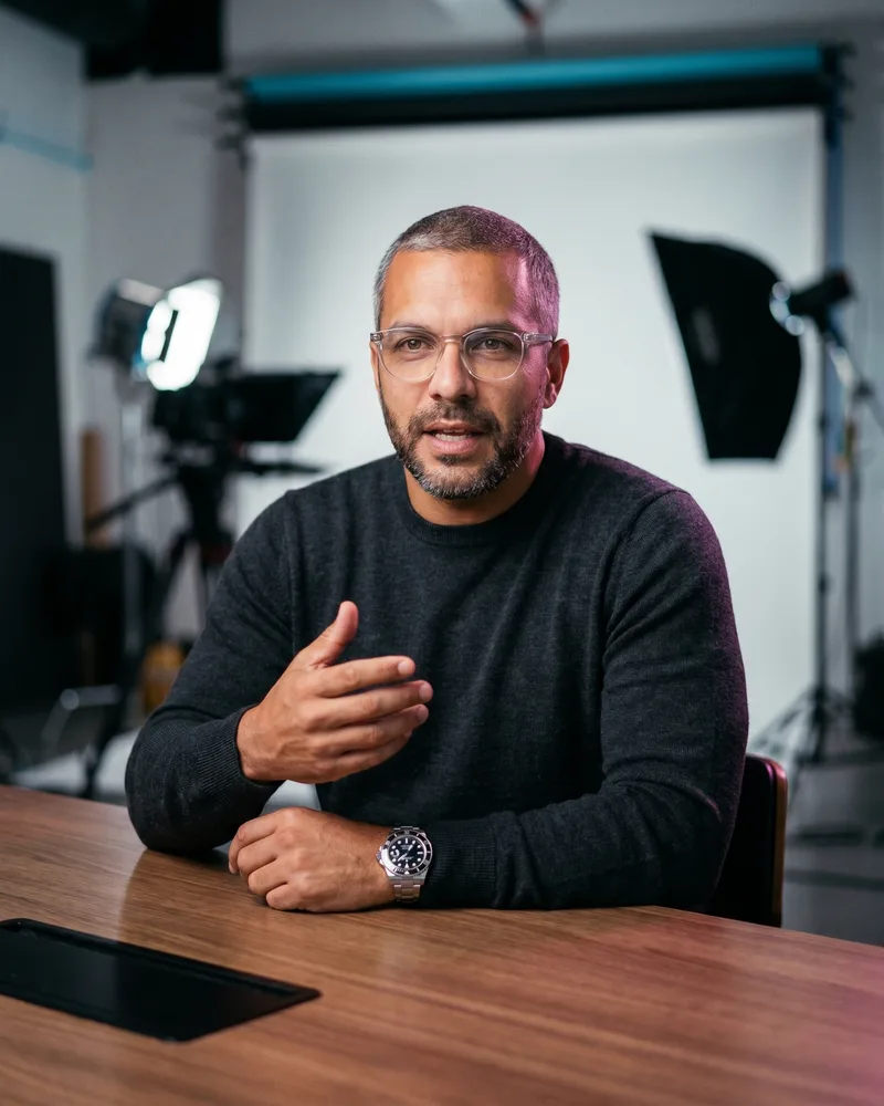 A frame of the same custom AI avatar Andre Laurent presenting to camera in a talking-head motion video, identity unchanged across formats, rendered by the Playcut Actor Engine